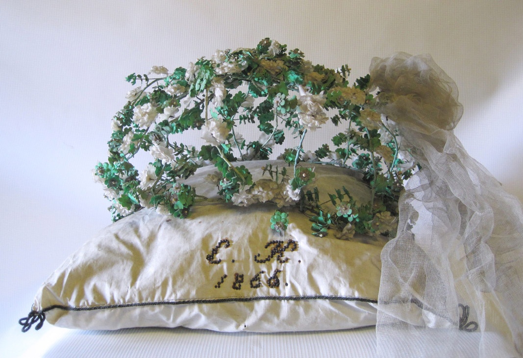 Couronne fun&eacute;raire compos&eacute;e de petites fleurs en lin blanc et de feuillage en papier vert le tout port&eacute; par un structure en fil m&eacute;tallique. R&eacute;alis&eacute;e &agrave; Altenburg, un quartier de Nienburg, Allemagne &copy; Museum Schloss Bernburg